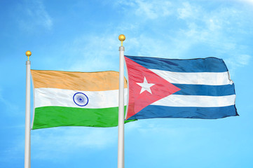 India and Cuba two flags on flagpoles and blue cloudy sky