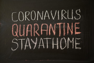 inscription stay at home. Outbreak Warning. written white chalk on blackboard in connection with epidemic of coronavirus worldwide.