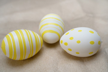 Easter eggs colored  yellow white decorated on craft paper background. Happy Easter card with copy space for text. Minimal eco easter style.