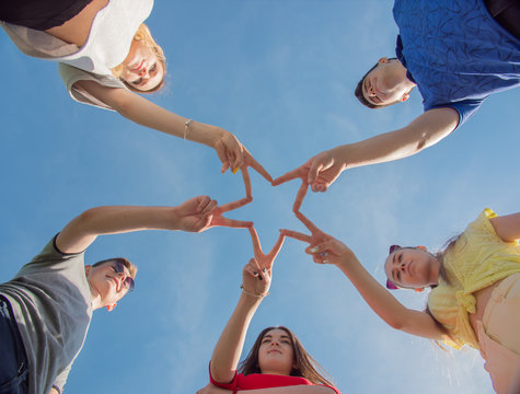 Friends make a star shape from their hands.