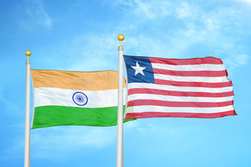 India and Liberia two flags on flagpoles and blue cloudy sky