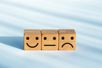 Service evaluation concept. Feedback rating. Smiley icon on wooden dice