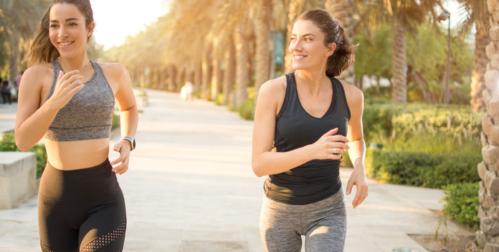 Two beautiful female joggers training in the park