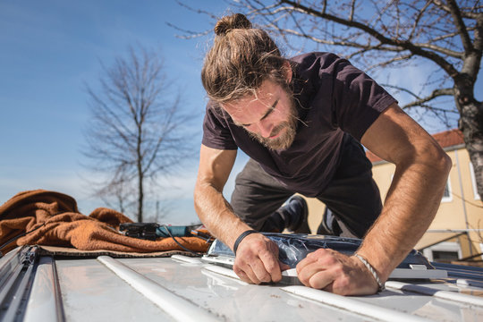 Man working on the roof of his camper van