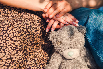 Toy teddy bear on the background of human hands.