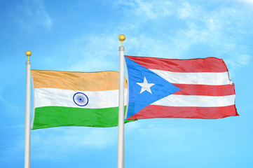 India and Puerto Rico two flags on flagpoles and blue cloudy sky