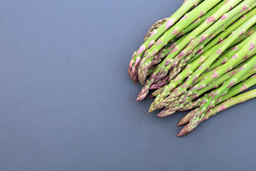 bunch of asparagus on a grey background.