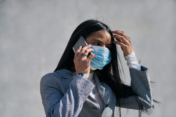 Girl with a mask to avoid contagion walking down the street. Coronavirus concept