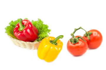 Ripe fresh organic vegetables in a basket and tomatoes on a branch in drops of dew isolated on a white background