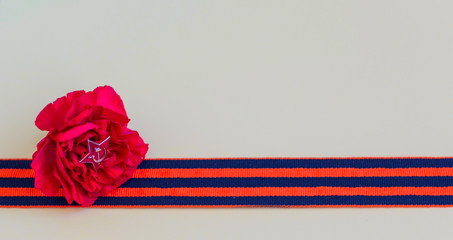 carnation and George's ribbon for great Patriotic War in Russia (USSR), copy space, greeting card, the day of victory in Russia