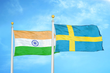 India and Sweden two flags on flagpoles and blue cloudy sky