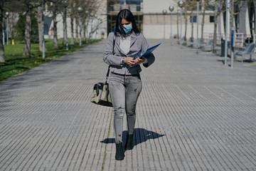 Girl with a mask to avoid contagion walking down the street. Coronavirus concept