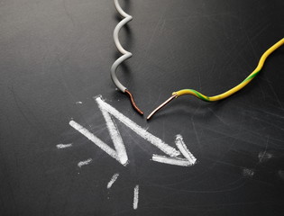 Damaged, cut insulated wires on blackboard, chalkboard black surface with chalk drawing