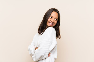 Young brunette woman with white sweater over isolated background laughing