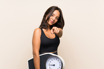 Young sport girl with weighing machine over isolated background