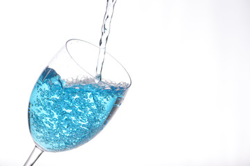 blue liquid pouring into a wine glass