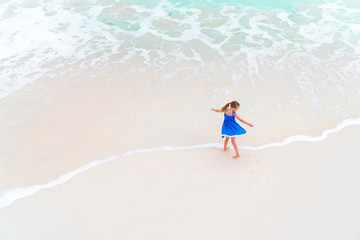 Adorable little girl have fun at tropical beach during vacation