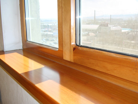 Fototapeta a window and a window sill from larch, from a natural tree, repair in a house installation of high-quality windows