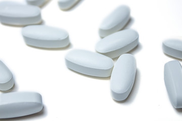 Tablets. Pills background. Pills and tablets in white on a white background. Macro. Copy space