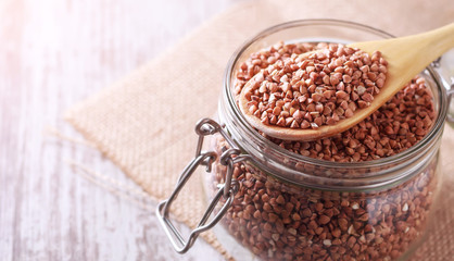 Transparent glass jar with buckwheat on the table. Quarantine Product Stock