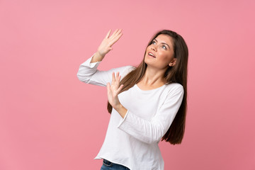 Young woman over isolated pink background nervous and scared