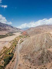 Andes Mountains, Cerro de los Siete Colores, Purmamarca Jujuy, Argentina colourful rock formation village and blue sky