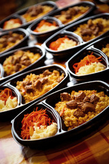 hot dish of meat and vegetables,with a side dish in a disposable container,for delivery of food at home