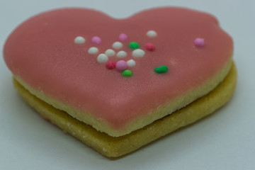 Close-up macro view of the edge of Christmas cookies in the form of a pink heart and its corpus in close up shot