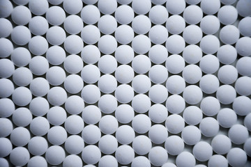 White tablets folded on a pharmaceutical factory production line close up pattern