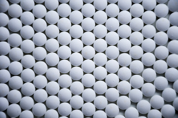 White tablets folded on a pharmaceutical factory production line close up pattern