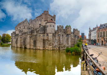 Fototapeta na wymiar Ghent/Belgium - October 10, 2019: View from the river of the castle of Ghent in Belgium with blue sky and white clouds..