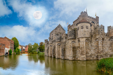 Obraz premium View from the river of the castle of Ghent in Belgium with blue sky and white clouds..