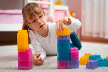 Stock image of little girl playing with construction blocks