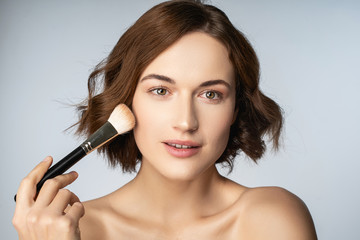 Fototapeta premium Attractive brunette female person testing decorative cosmetics
