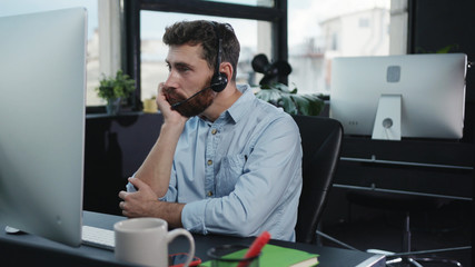 Bored young customer service executive talking with client on consulting phone call getting tired...