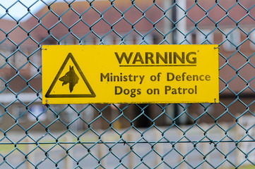 Sign at a military site warning that dogs are on patrol