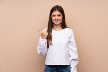 Young girl over isolated background pointing to the side to present a product