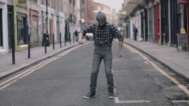 Hipster Male dancing in street looking to camera, London, England