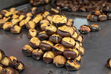 Roasted chestnuts for sale on street. Delicious and healthy snacks. Cooked fast food.