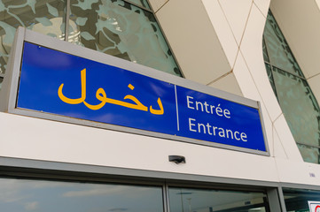 Obraz premium Sign for an entrance in Arabic, French and English
