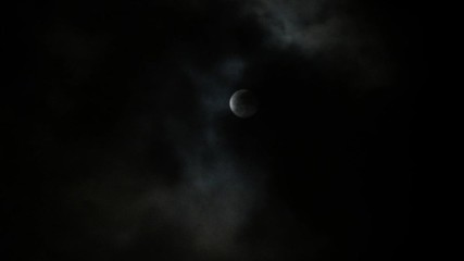 Full glowing yellow moon with clouds being blown by winds during storm at nights.