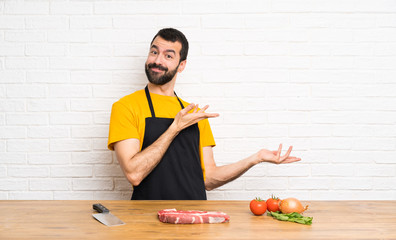 Chef holding in a cuisine extending hands to the side for inviting to come