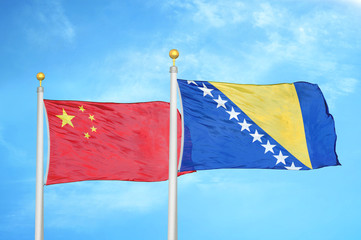 China and Bosnia and Herzegovina two flags on flagpoles and blue cloudy sky