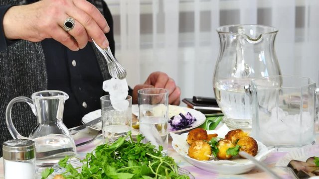 Adding water into RAKI. In the bottle raki is absolutely clear but when you mix it with ice or water for drinking it turns into milky white. It is often served in flat cylindrical glasses with meze
