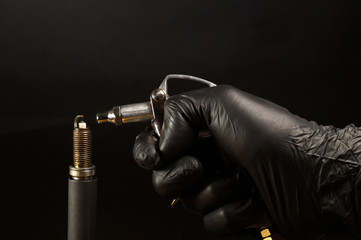 Cleaning the spark plug with compressed air. Internal combustion engine service. - obrazy, fototapety, plakaty