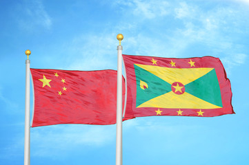 China and Grenada two flags on flagpoles and blue cloudy sky