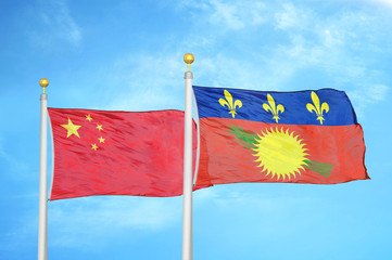 China and Guadeloupe two flags on flagpoles and blue cloudy sky