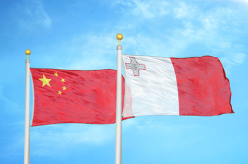 China and Malta two flags on flagpoles and blue cloudy sky