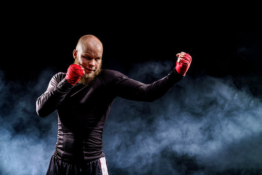 Sportsman boxer fighting on black background with smoke. Boxing sport concept.