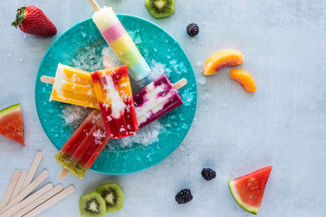 A top down view of a plate of homemade fruit puree popsicles ready for eating.